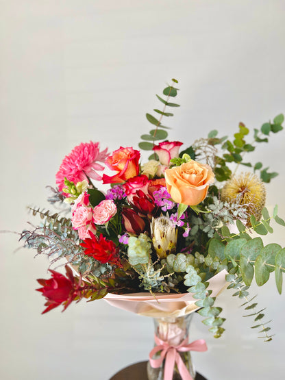 Seasonal, native, roses and foliages in a bouquet.